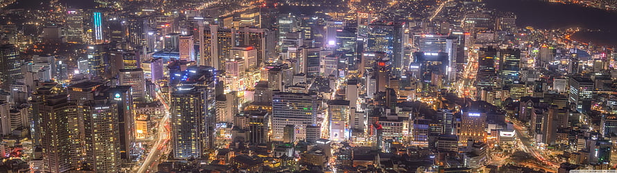 Aerial Night View of a Dense Metropolitan City Skyline with Glowing Skyscrapers HD wallpaper