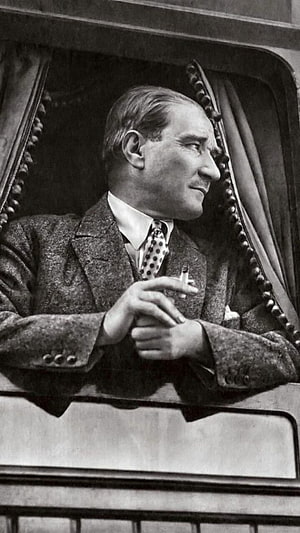 Mustafa Kemal Ataturk in a tweed suit holding a cigarette in a vintage black and white portrait HD phone wallpaper