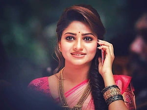Rachita Ram in a pink sari holding a phone with traditional gold jewelry HD wallpaper