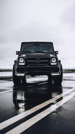 Black Mercedes G-Class SUV Front View on Wet Asphalt Road with LED Lights and Reflections HD phone wallpaper