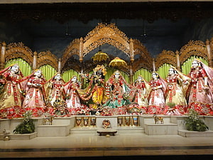 Ornate Golu Doll Display at Mayapur Temple with Traditional Attire and Golden Arch HD wallpaper