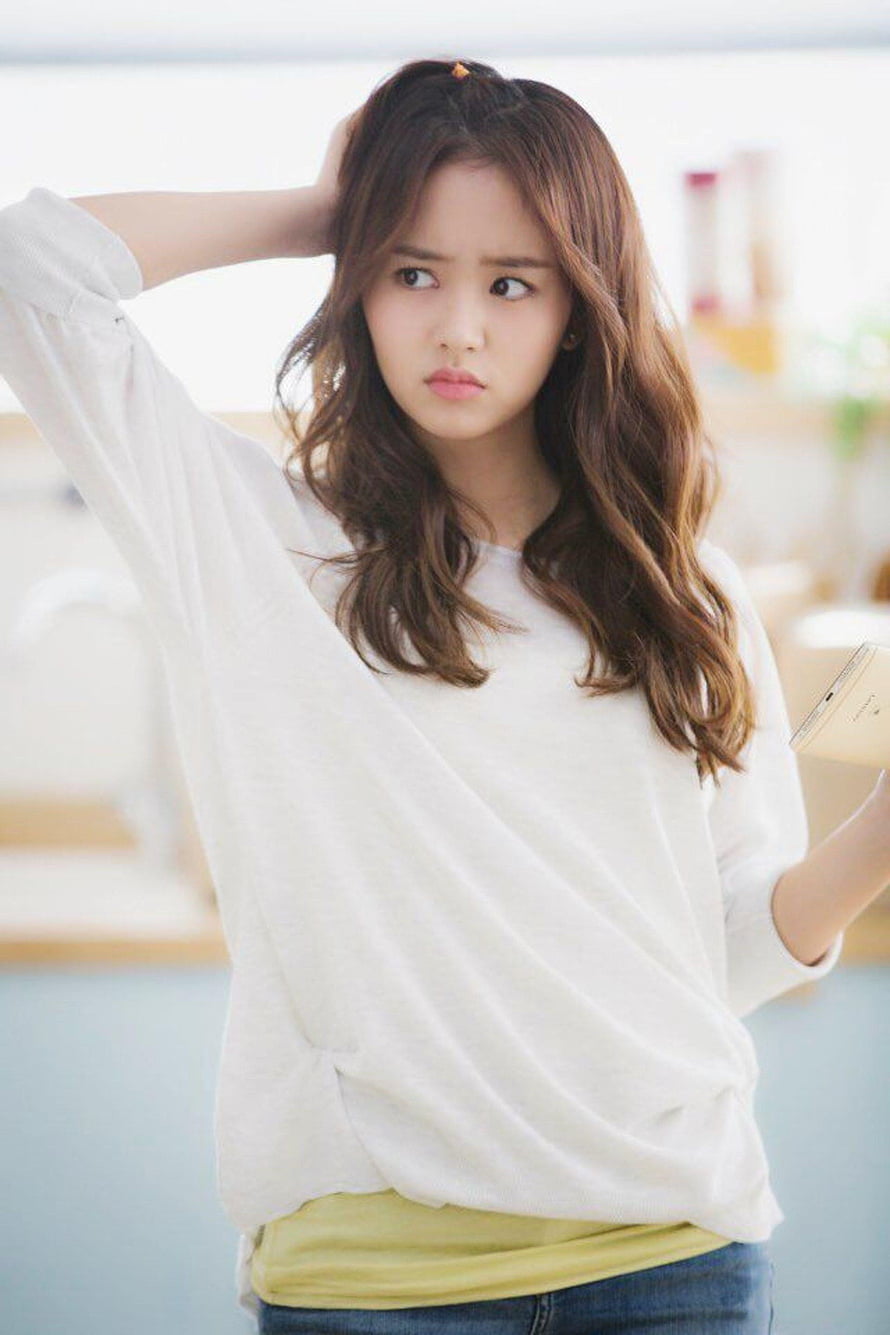 Kim So Hyun in a white sweater and yellow top with a pensive expression HD phone wallpaper