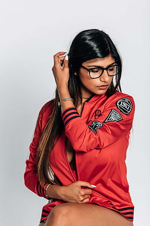 Mia Khalifa in a red New York Knicks basketball jersey with black framed glasses HD phone wallpaper