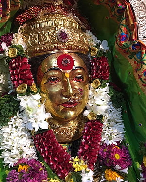 Golden Murti of Goddess Ekvira Adorned with Floral Garlands and Traditional Crown HD phone wallpaper
