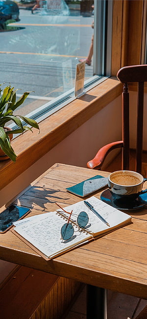 Cozy Cafe Study Scene with Coffee, Notebook, and Sunglasses on a Wooden Table HD phone wallpaper