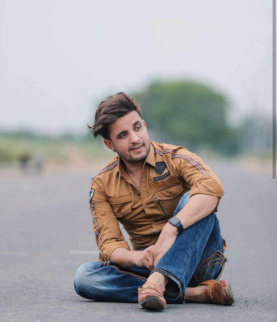 R Nait Sitting on Asphalt Road in Casual Brown Shirt and Jeans HD phone wallpaper