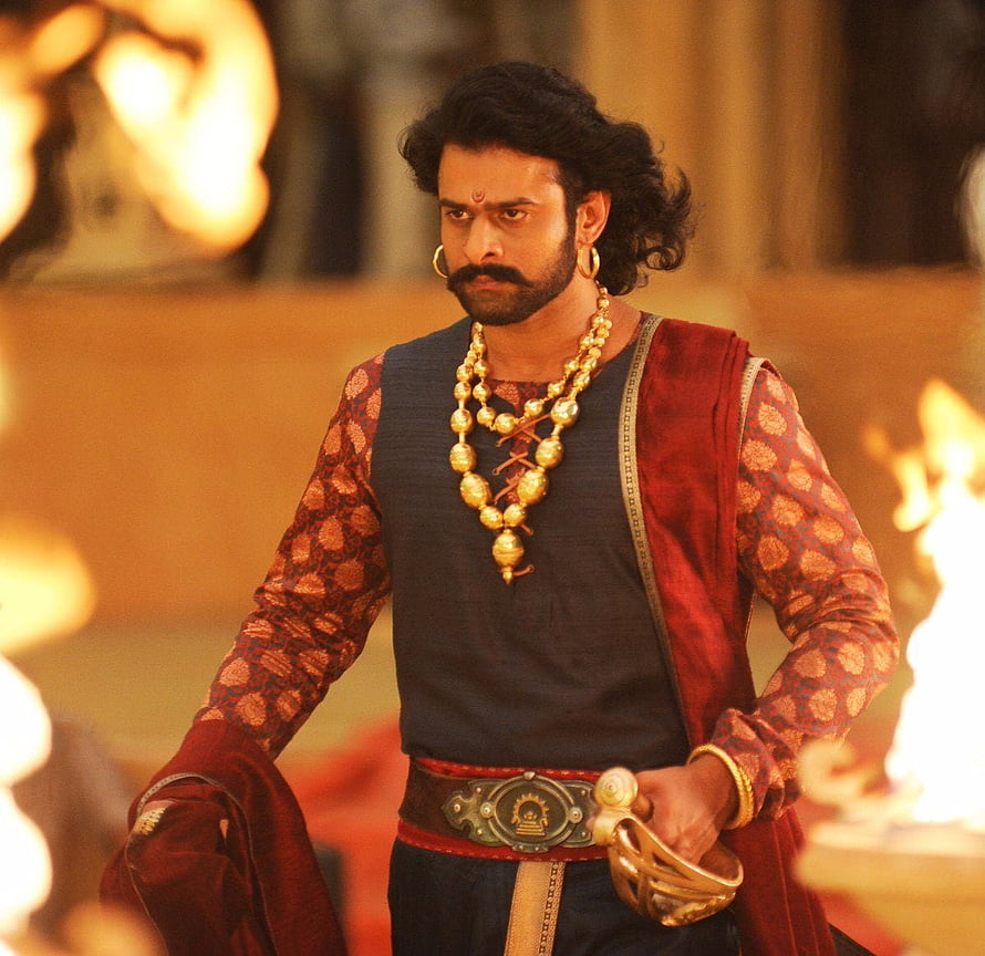 Prabhas as Baahubali in ornate royal costume with gold jewelry and ceremonial regalia HD wallpaper