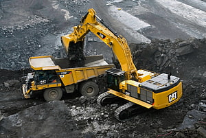 Caterpillar 390F Excavator Loading 775F Haul Truck in Open Pit Mine HD wallpaper