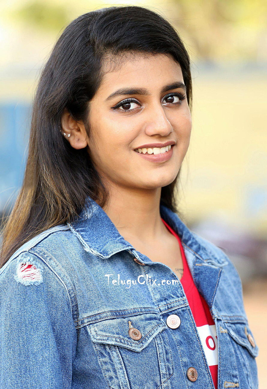 Priya Prakash Varrier smiling portrait in a distressed denim jacket and red top HD phone wallpaper