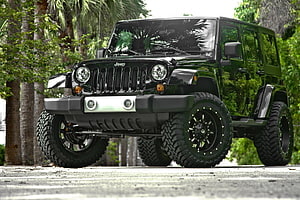 Black Jeep Wrangler with Off-Road Tires and Custom Bumper in Tropical Setting HD wallpaper