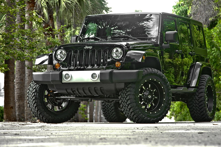 Black Jeep Wrangler with Off-Road Tires and Custom Bumper in Tropical Setting HD wallpaper