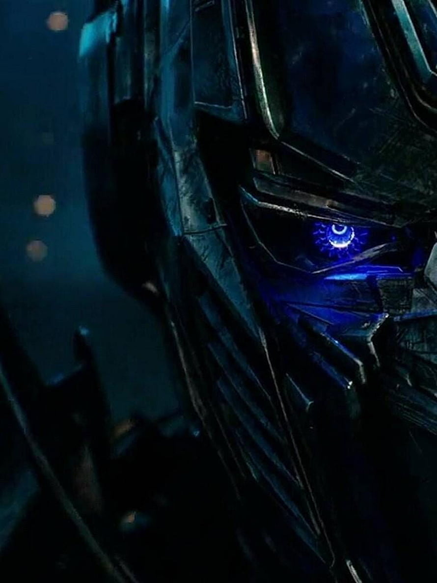 Optimus Prime Close-Up Portrait with Glowing Blue Eye in Dark Cinematic Lighting HD phone wallpaper