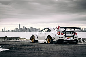 White Nissan GT-R R35 with Liberty Walk Widebody and Gold Wheels Parked on a Pier in New York City HD wallpaper