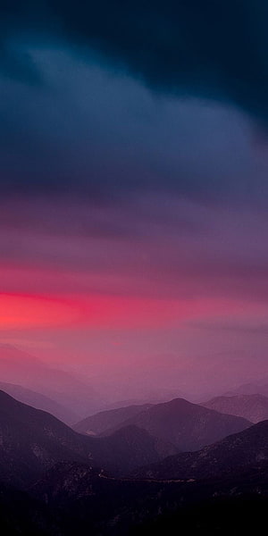 Vibrant pink and purple sunset sky over layered mountain ridges at dusk HD phone wallpaper