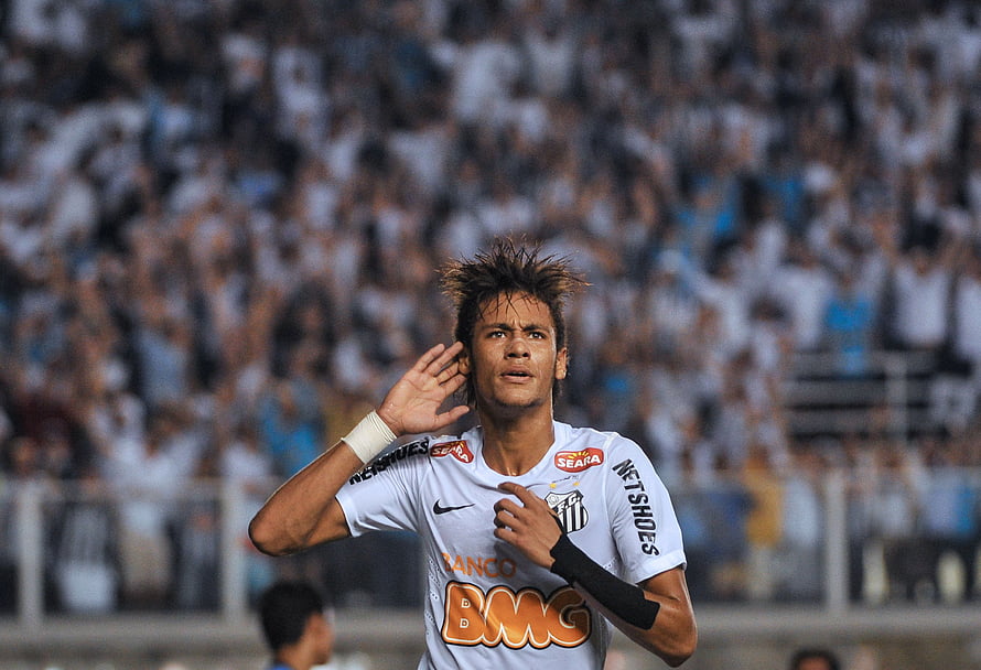 Neymar in Santos FC white home kit celebrating with hand to ear in front of packed stadium crowd HD wallpaper