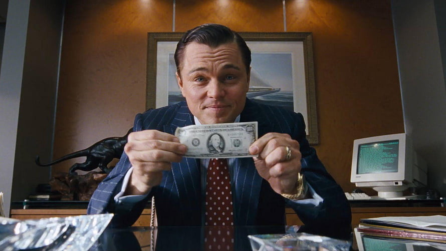 Leonardo DiCaprio as Jordan Belfort in The Wolf of Wall Street holding a dollar bill in a luxury office HD wallpaper
