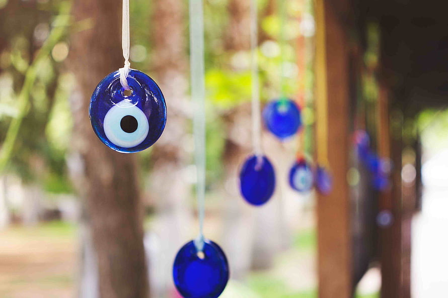 Blue Evil Eye Glass Charms Hanging in a Garden HD wallpaper