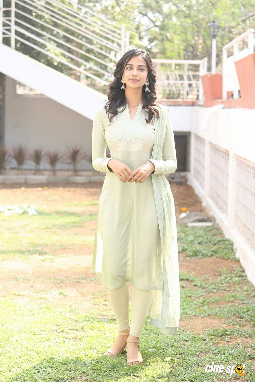 Meenakshi Chaudhary in a pastel green embroidered kurta and dupatta standing outdoors HD phone wallpaper