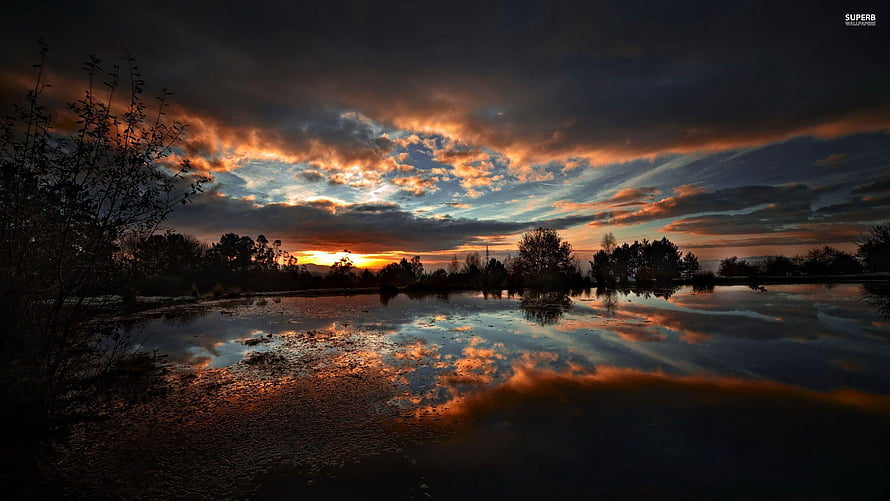 Dramatic Sunset Over a Calm Lake with Vivid Cloud Reflections HD wallpaper
