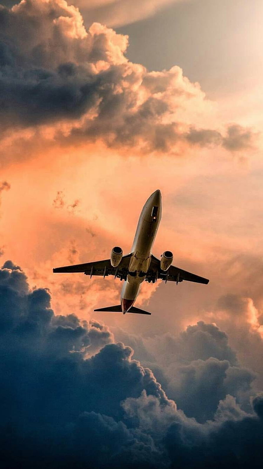 Commercial Jetliner Ascending Through Dramatic Sunset Clouds HD phone wallpaper