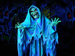Eerie Ghostly Figure in Tattered Blue Robe with Glowing Red Eyes in Dark Forest HD wallpaper