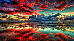 Vibrant Crimson Clouds Reflected in Shallow Tidal Pools at Sunset HD wallpaper