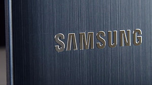 Close-up of the Samsung brand logo on a brushed metal surface HD wallpaper