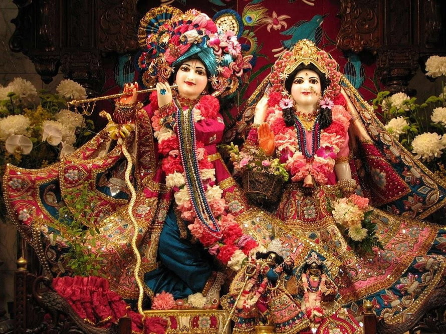 Radha Krishna Temple Deities Adorned in Vibrant Floral Garlands and Ornate Traditional Attire HD wallpaper
