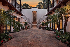 Modern Hacienda Courtyard with Split Staircase and Lush Tropical Landscaping at Sunset HD wallpaper