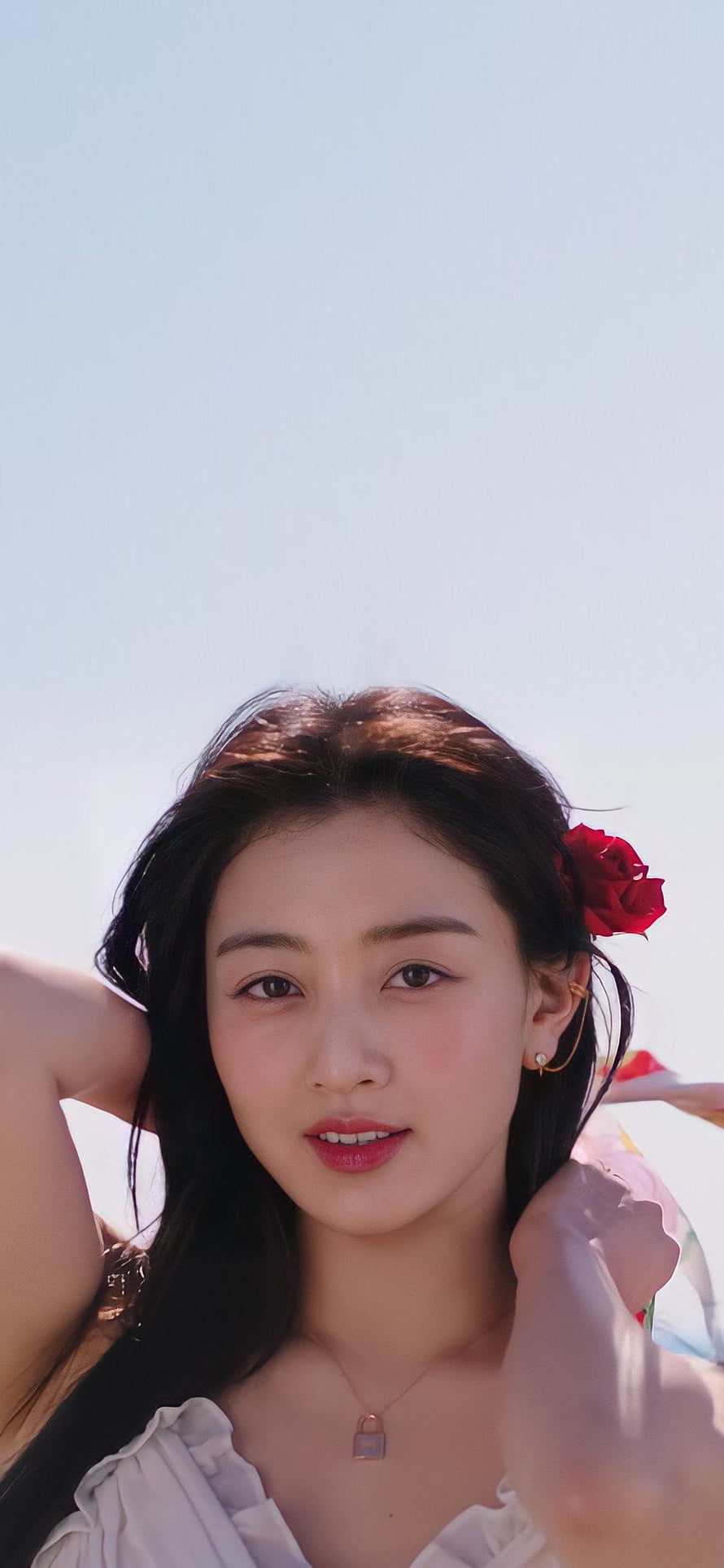 Jihyo from TWICE in a soft white top with a red rose tucked in her hair against a bright sky HD phone wallpaper