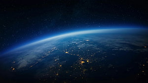 Earth at Night From Orbit: City Lights and Atmospheric Glow Against the Starry Cosmos HD wallpaper