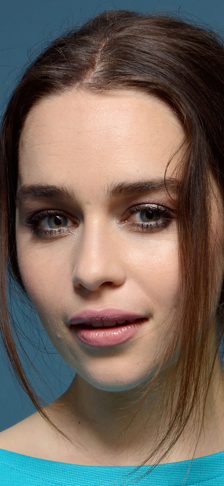 Emilia Clarke Close-Up Portrait with Brown Hair and Blue Background HD phone wallpaper