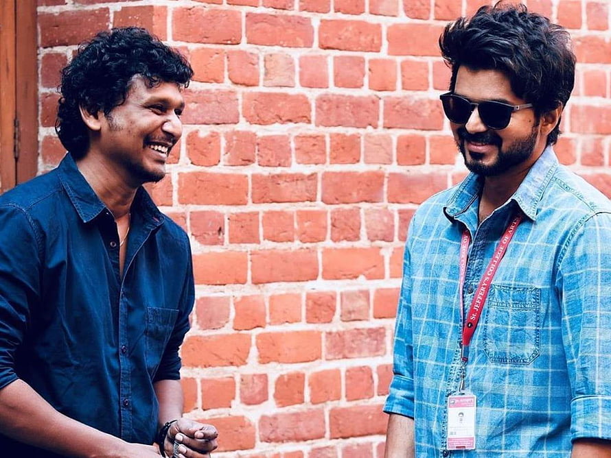 Lokesh Kanagaraj and Vijay smiling together in front of a red brick wall HD wallpaper