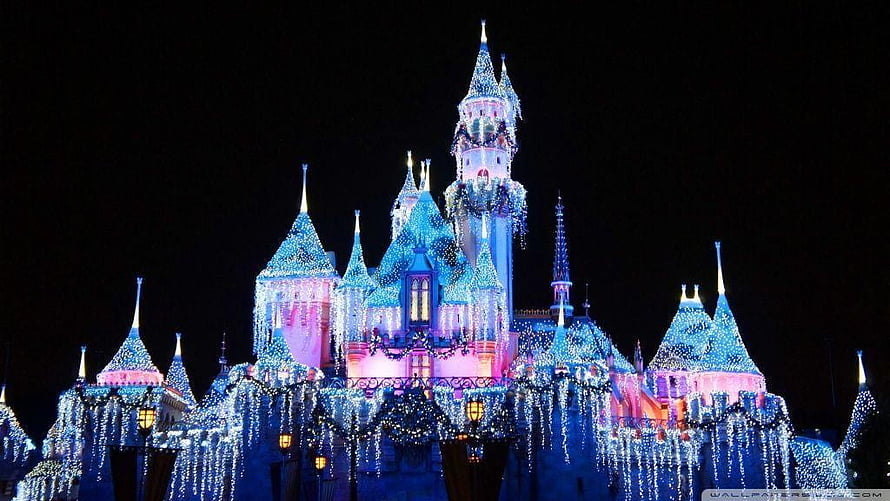 Illuminated Fairy Tale Castle at Night with Festive Holiday Lights and Sparkling Blue and Pink Glow HD wallpaper