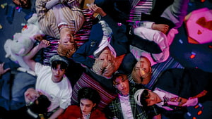 Stray Kids members lying on colorful striped bedding with plush toys and vibrant pink lighting HD wallpaper