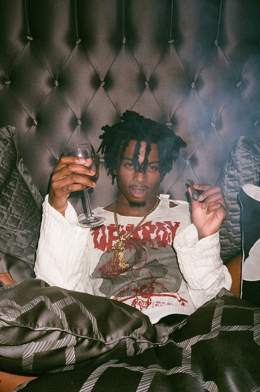 Young Rapper Holding Wine Glass and Cigarette on Tufted Headboard HD phone wallpaper