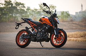 KTM 200 Duke motorcycle in orange and black parked on an open road at golden hour HD wallpaper