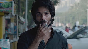 Kabir Singh Movie Still: Intense Portrait of a Bearded Man Smoking on a City Street HD wallpaper