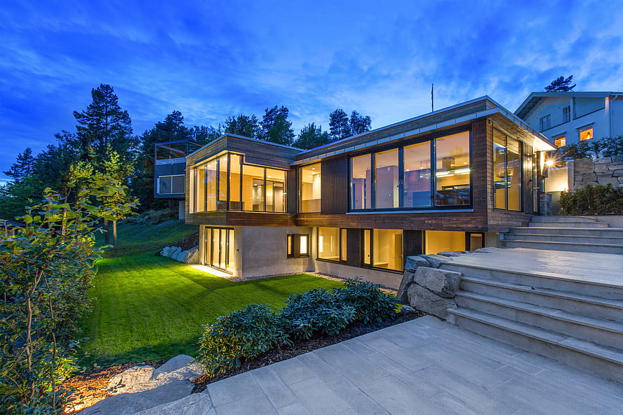 Modern Luxury Home with Floor-to-Ceiling Windows at Dusk HD wallpaper