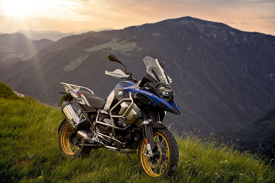 BMW R 1250 GS Adventure Motorcycle Parked on a Grassy Mountain Ridge at Sunset HD wallpaper
