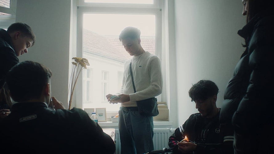 Young men gathered in a dimly lit room with a lit candle and dried flowers HD wallpaper