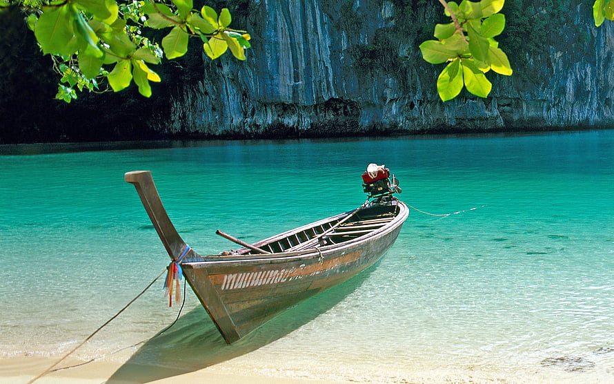 Traditional Long Tail Boat Moored in Turquoise Lagoon with Limestone Cliffs HD wallpaper