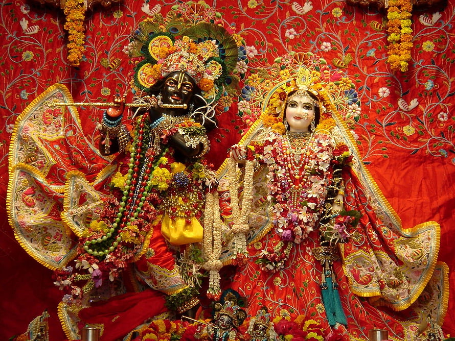 Banke Bihari and Sita Murti adorned in vibrant floral garlands and traditional red temple attire HD wallpaper