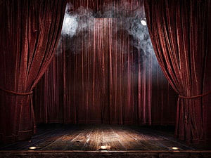 Moody Theater Stage With Deep Red Velvet Curtains, Hazy Spotlight Beams, and Weathered Wooden Floor HD wallpaper