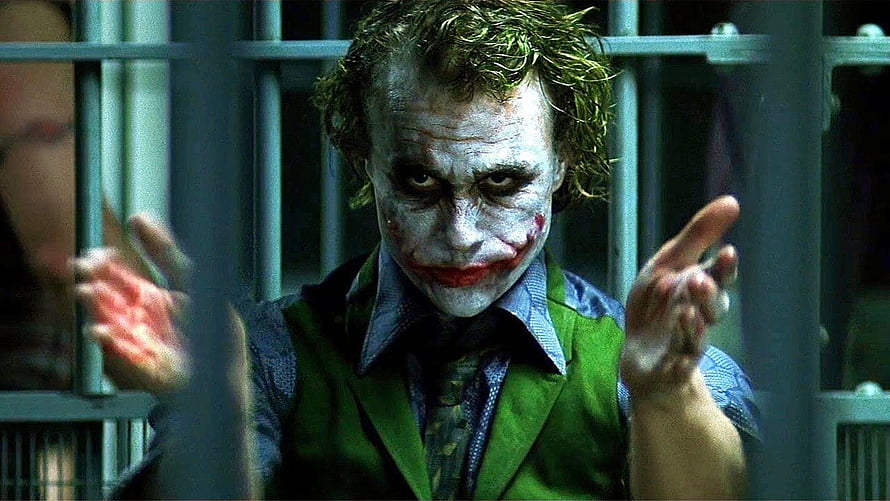 Joker in Green Suit Behind Prison Bars with White Face Paint and Red Lips HD wallpaper
