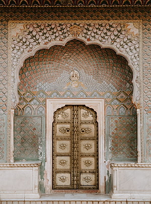 Ornate Mughal Archway with Intricate Floral Tilework and Carved Wooden Doors HD phone wallpaper