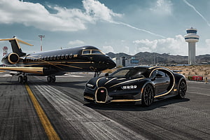 Black and Gold Bugatti Chiron Parked Beside a Private Jet at an Airport Tarmac HD wallpaper