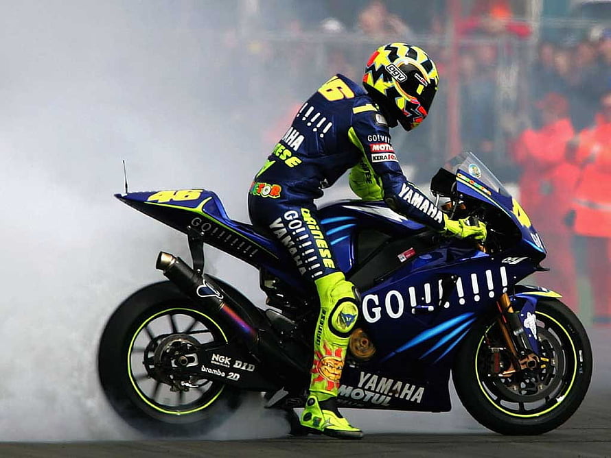 Valentino Rossi performing a burnout on his Yamaha MotoGP race bike HD wallpaper