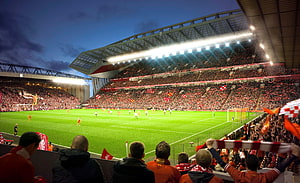 Anfield Stadium at Night with Liverpool Fans and Match Action HD wallpaper