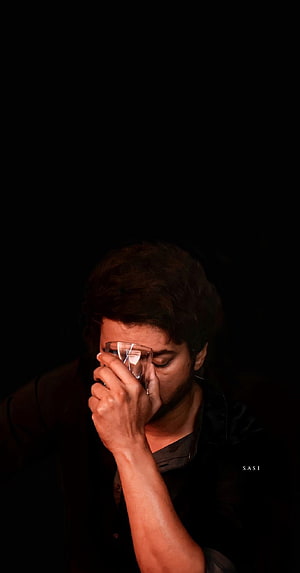 Ilayathalapathy Vijay in a moody portrait holding a glass against his face in dramatic low light HD phone wallpaper
